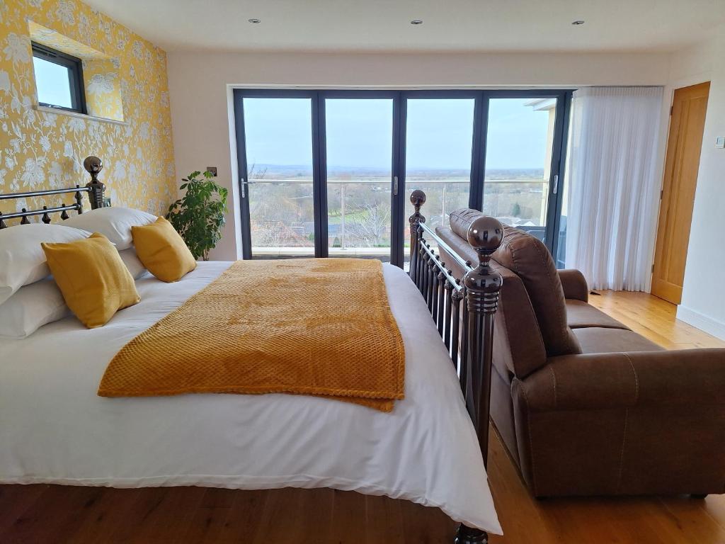 a bedroom with a bed and a couch and a window at A Room with a View in Glastonbury