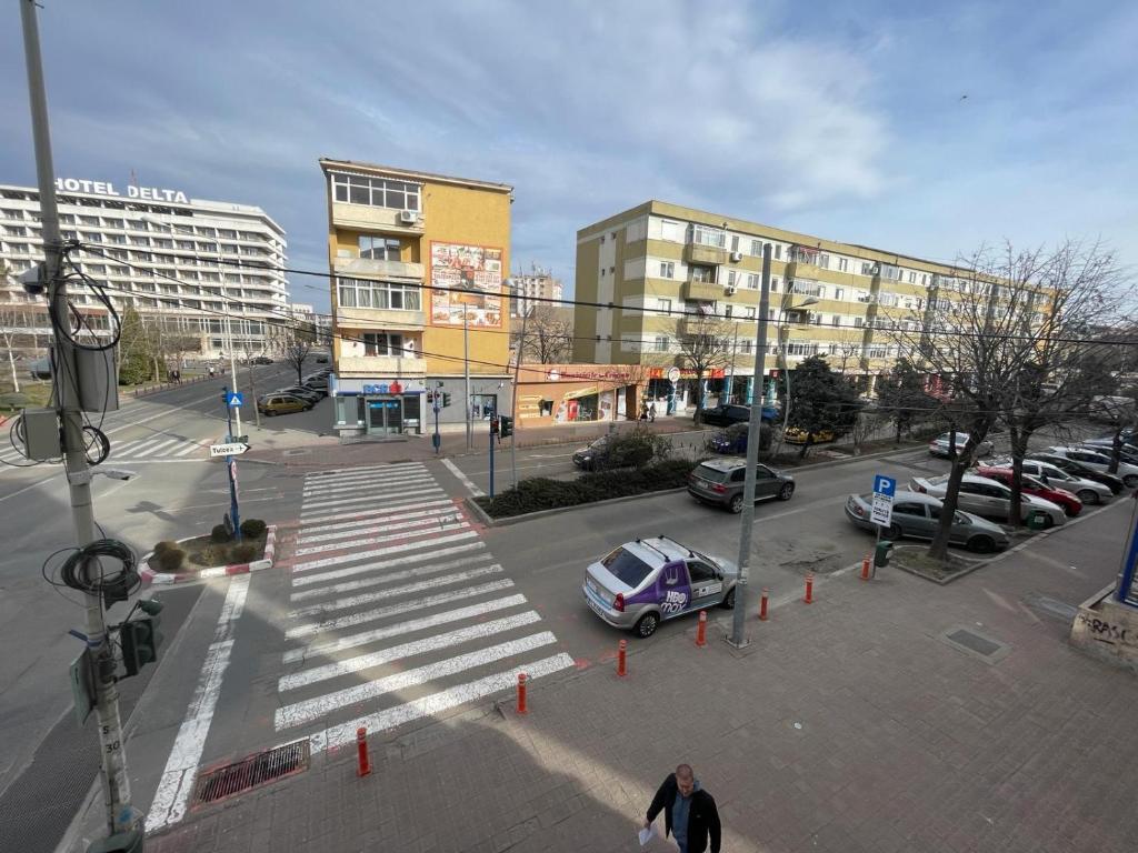 a city street with cars parked in a parking lot at Apartament Central Tulcea in Tulcea