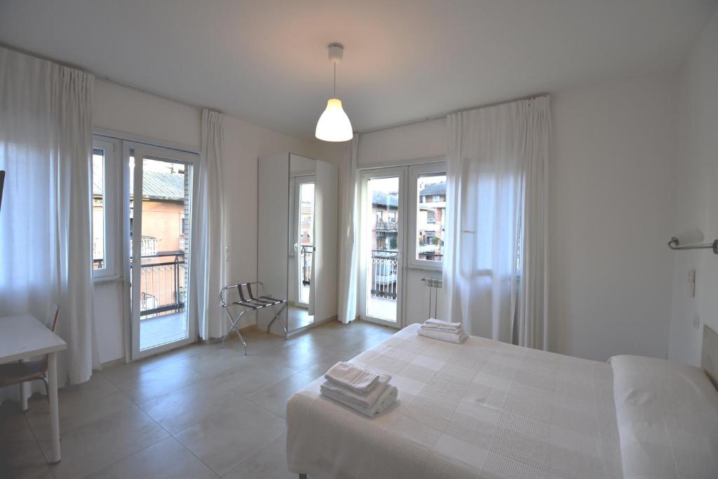 a white bedroom with a white bed and windows at Guesthouse Vassallo Uno in Rome