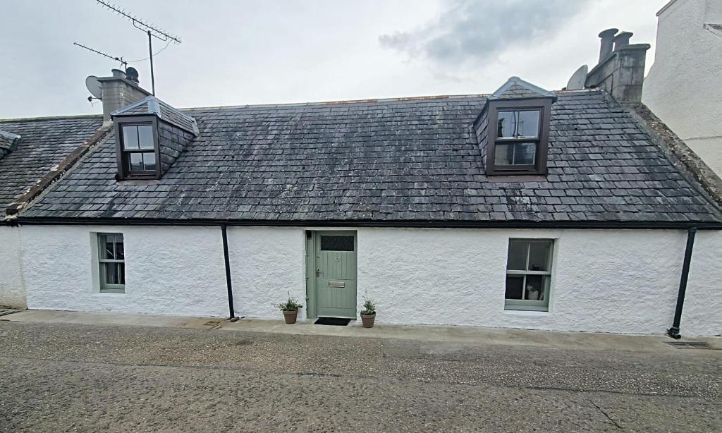 Casa blanca con puerta verde y ventanas en North Coast Property - 17 Margaret Street - Avoch en Avoch