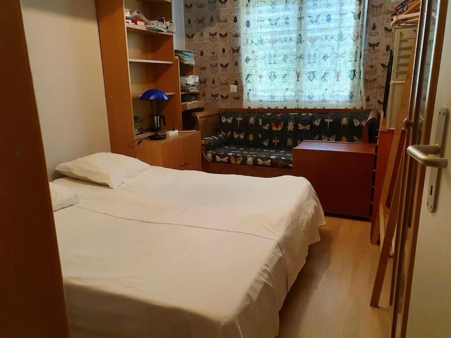 a small bedroom with two beds and a window at Appart. 3 chambres, jacuzzi en été, dans un jardin in Geneva