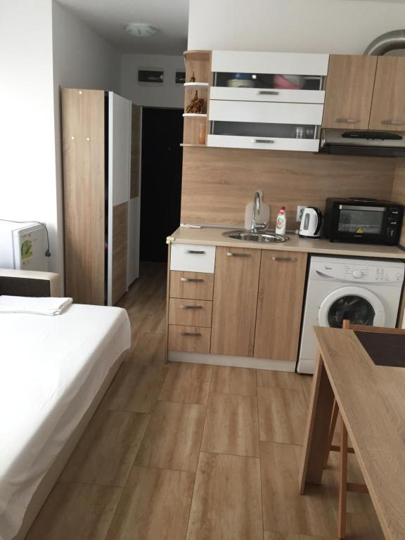a room with a bed and a kitchen with a sink at Studio Zori in Burgas City