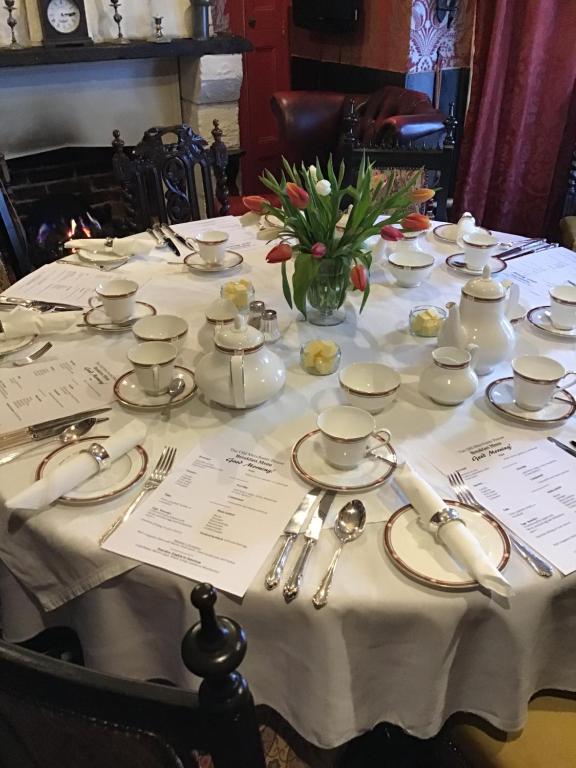 uma mesa com uma toalha de mesa branca e um vaso de flores em The Old Merchants House - The Highlands Room em Southampton