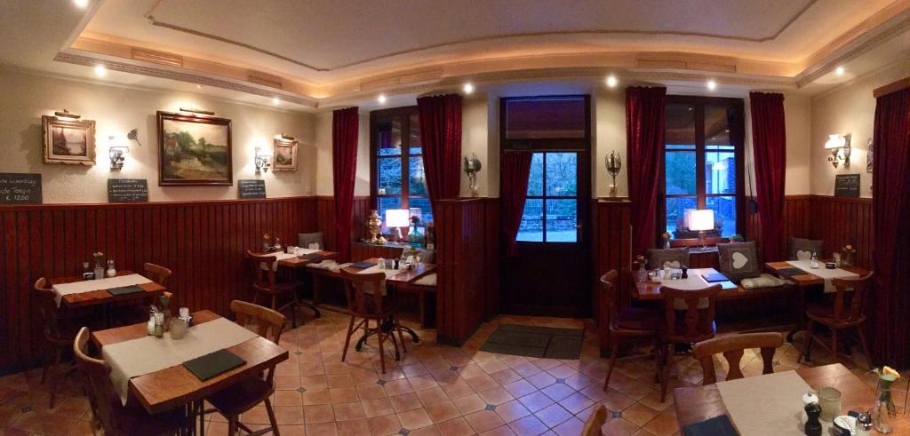 a restaurant with tables and chairs in a room at Hotel Auberge Rustique in Beaufort
