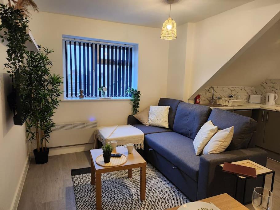 ApartHotel Flat 7: Keyless Entry. 10 min to centre by Property Promise في كارديف: غرفة معيشة مع أريكة زرقاء وطاولة