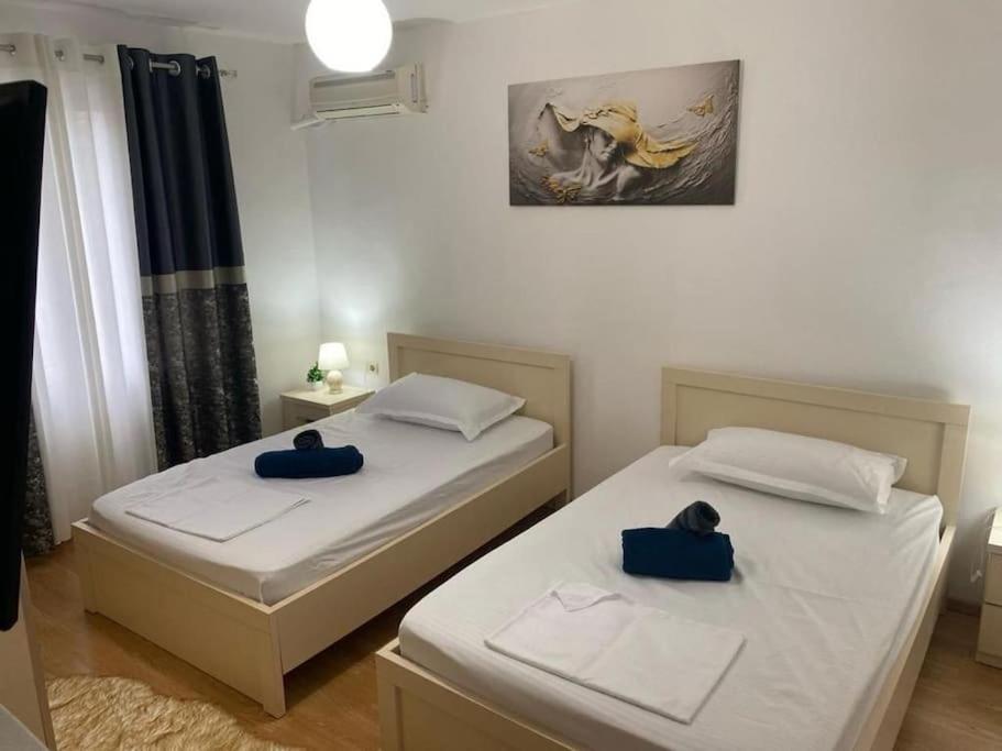Duas camas num quarto com almofadas azuis em Cozy Apartment em Tirana