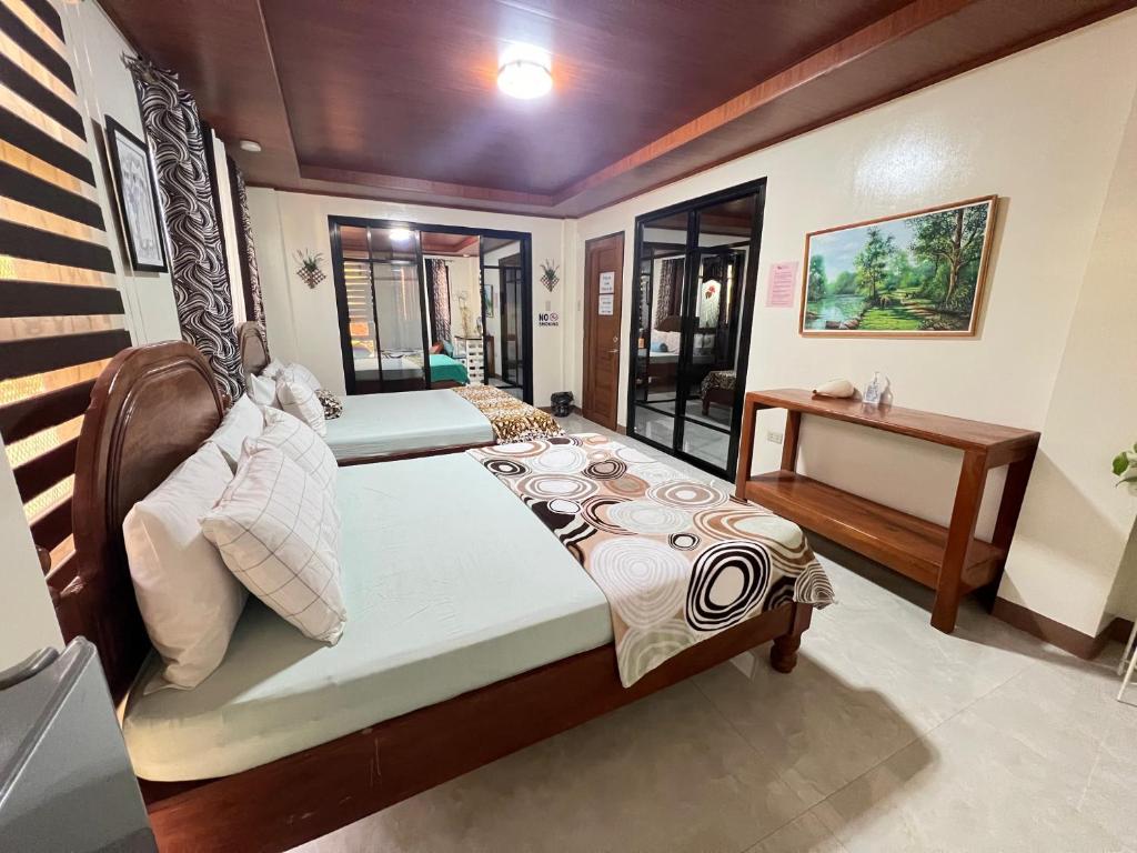 a bedroom with two beds and a desk in it at Villa Lourdes in Alaminos