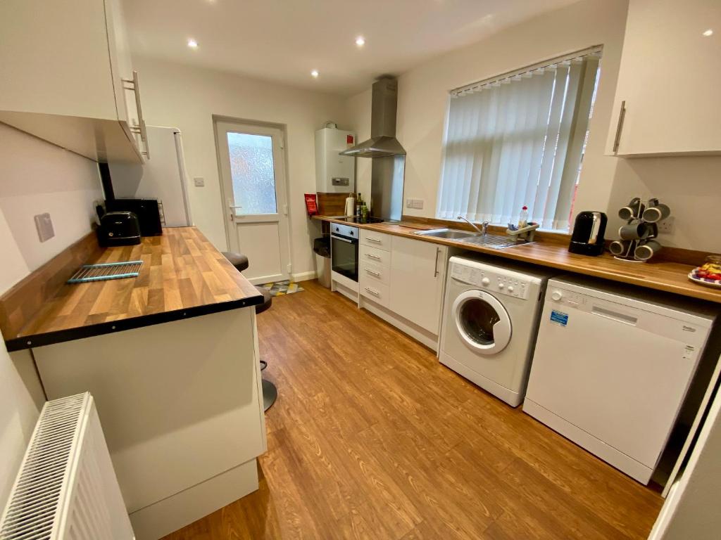 a kitchen with a washer and dryer in it at Eden Stay in Morecambe