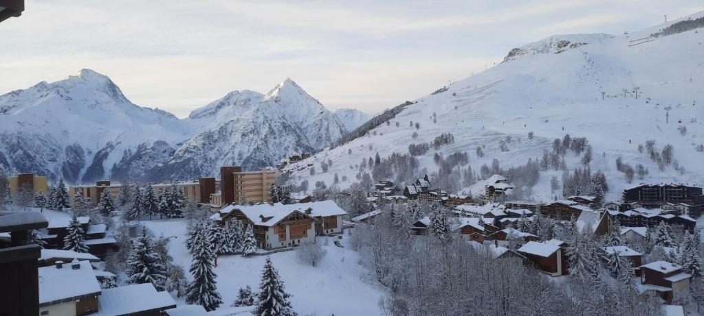 a village covered in snow with mountains in the background at Studio Cabine 4 pers Les2Alpes 21m² in Les Deux Alpes