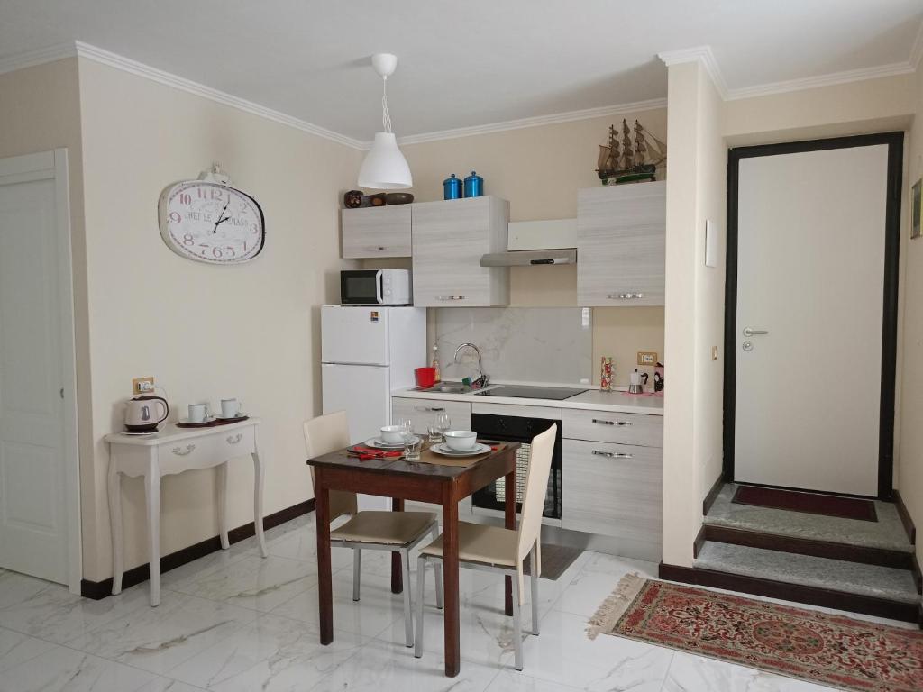 een keuken met een houten tafel en een tafel met stoelen bij Il nido di Ele in Stresa