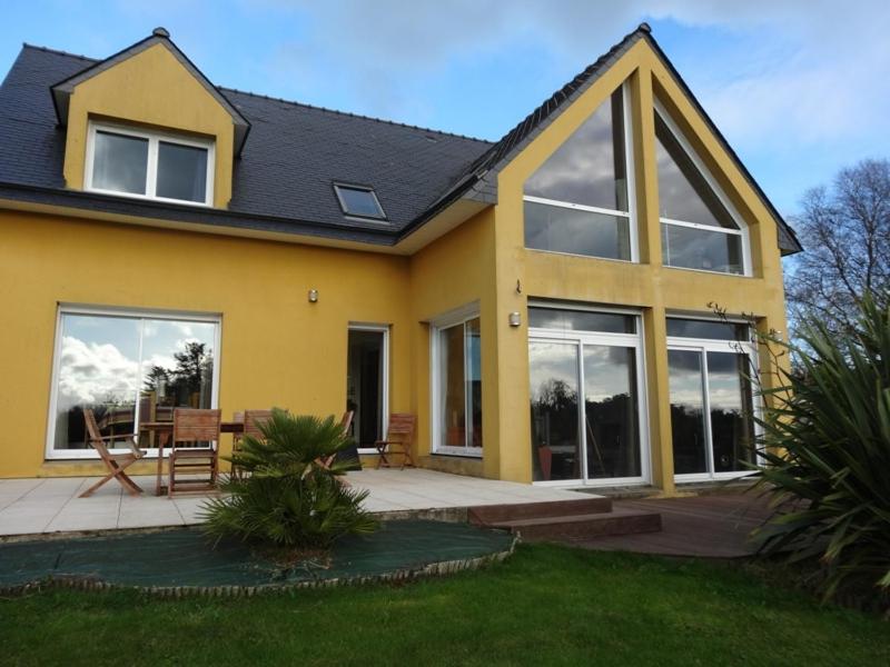 een geel huis met een tafel en stoelen bij Charmante maison moderne entre terre et mer in Coray
