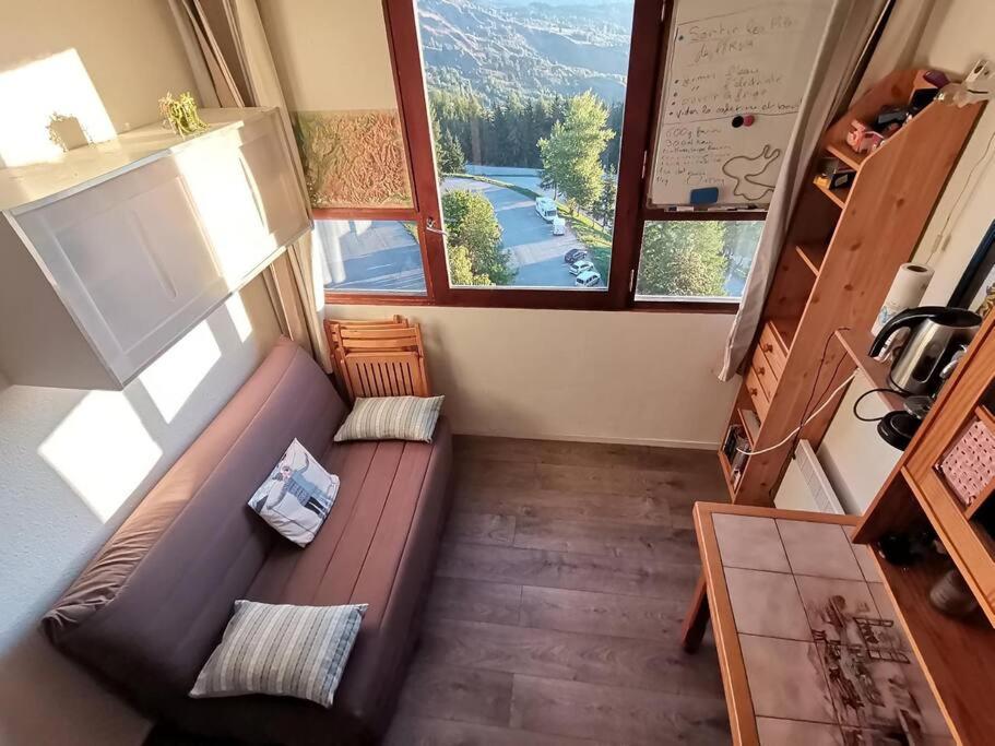 un salon avec un canapé et une grande fenêtre dans l'établissement Sybelles - Corbier - Studio Skis aux pieds, à Villarembert