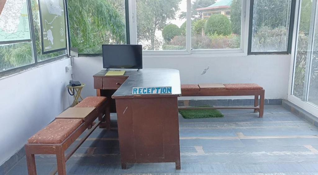 a room with a desk with a laptop on it at Himalayas Youth Hostel Kempty Mussoorie in Mussoorie