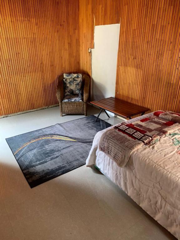a bedroom with a bed and a chair and a table at WINZMAR LODGE in Lusaka