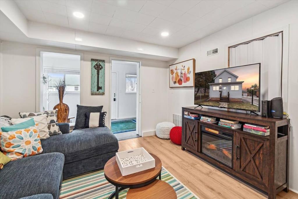 ein Wohnzimmer mit einem Sofa und einem TV in der Unterkunft White House Bungalow in Bay City
