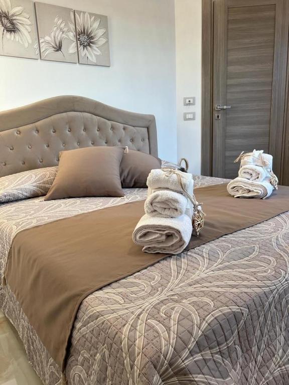 a bedroom with a bed with towels on it at La Corte del Moro in Pachino