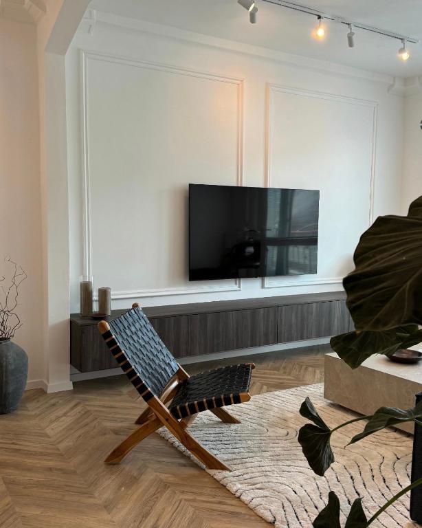 uma sala de estar com uma cadeira e uma televisão de ecrã plano em Kukučínova apartment em Bratislava