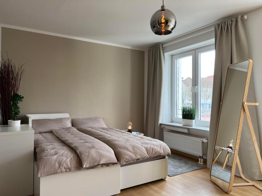 1 dormitorio con cama, espejo y ventana en Moderne Wohnung, zentral gelegen en Bielefeld
