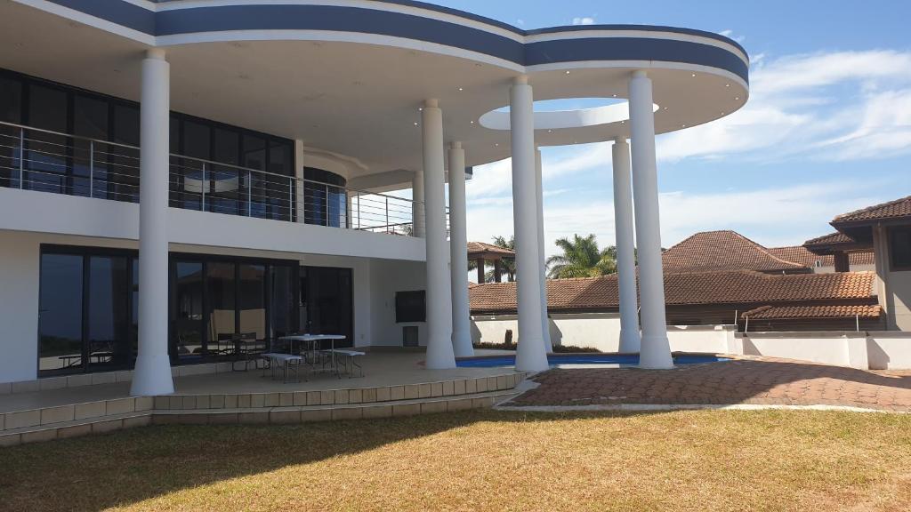 a large white building with columns and a patio at The Palace in Izinga Estate Umhlanga in Durban