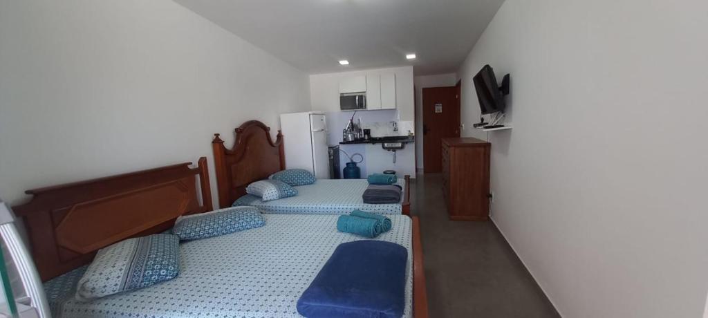 Habitación con 3 camas y almohadas azules. en Residencial 101 Ilha Grande, en Abraão