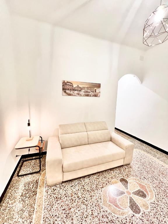 a white living room with a couch and a table at A due passi da Brignole in Genoa