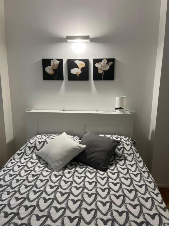 una camera con un letto con tre immagini appese al muro di Cherry's House Milano M1 rossa Bande Nere - San Siro a Milano
