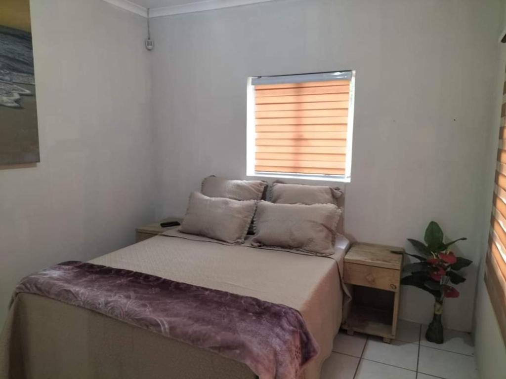 Habitación pequeña con cama y ventana en Restwell Accommodation, en Pietermaritzburg