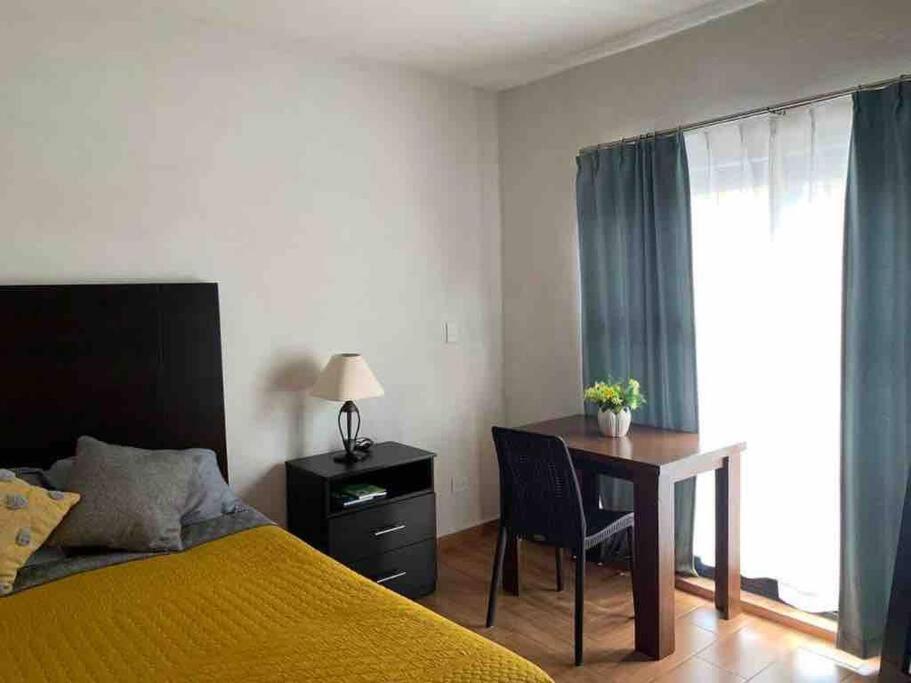 a bedroom with a bed and a desk and a table at Confortable Apartmento in Guanajuato