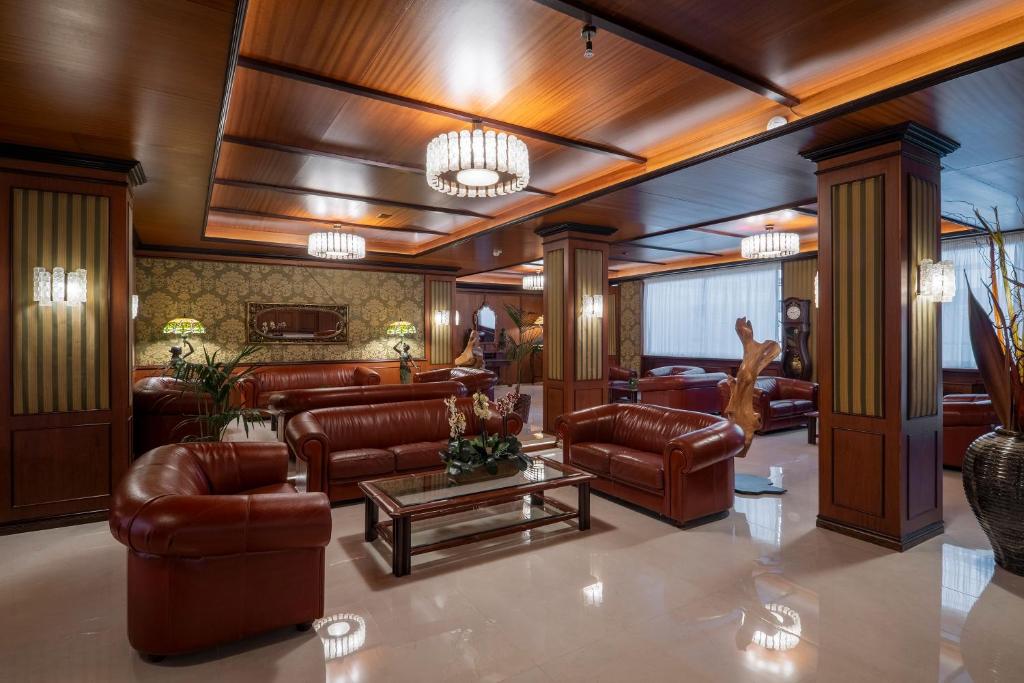 a lobby with leather couches and a table at Hotel Delle Palme in Lecce