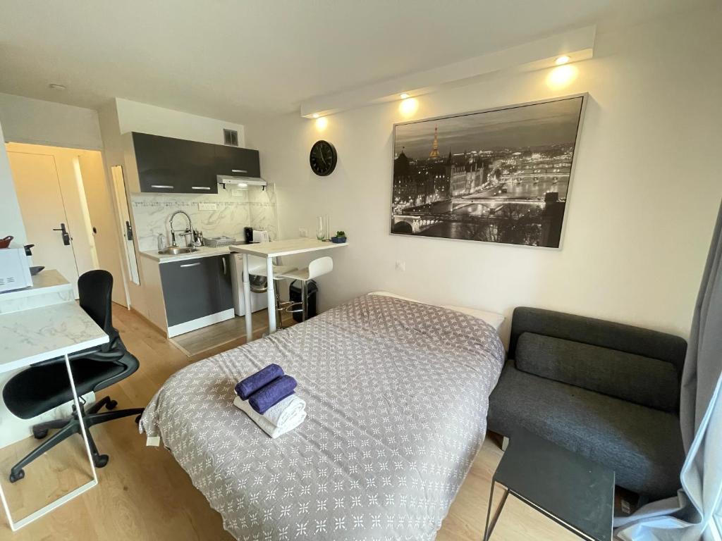 een slaapkamer met een bed, een bureau en een stoel bij Exclusive Private Apartment by Warilco - Pleyel 25 m2 - À 1 minute de la station métro Carrefour Pleyel in Saint-Denis