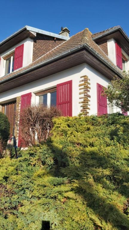 une maison avec des portes rouges au sommet d'une colline dans l'établissement Chez Toinette, à Bretteville-sur-Odon