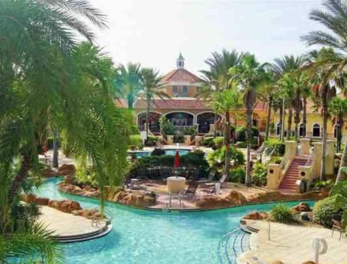a resort with a swimming pool and palm trees at Villas at Regal Palms-4 Bedroom3.5 bath Townhouse in Davenport