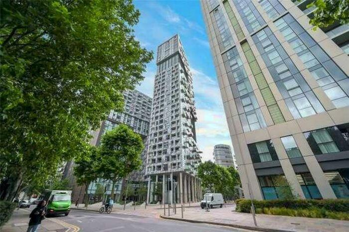 wysoki budynek przy ulicy miejskiej z samochodami w obiekcie Large Canary Wharf 2 Bed Apartment with High Rise view w Londynie