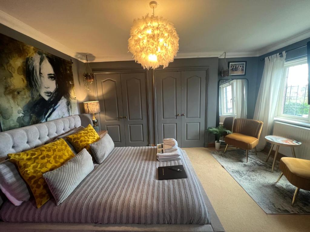 a living room with a large bed and a chandelier at Boutique Shrewsbury Rooms in Shrewsbury