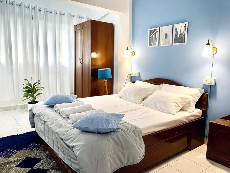 1 dormitorio con 1 cama grande con sábanas y almohadas blancas en Luxurious 1BHK with a Pool AniRah Homes in Colva, en Colva