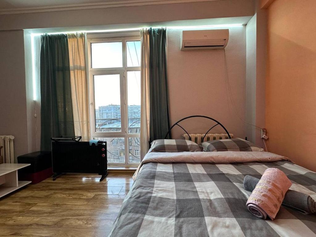 a bedroom with two beds and a large window at 1-room apart. 21 on Usenbaeva 52 near Eurasia shopping center in Bishkek