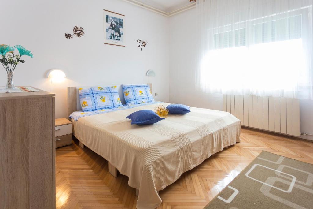 a bedroom with a large bed with blue pillows at Nice and spacious apartment- Silvio 2 in Banjole