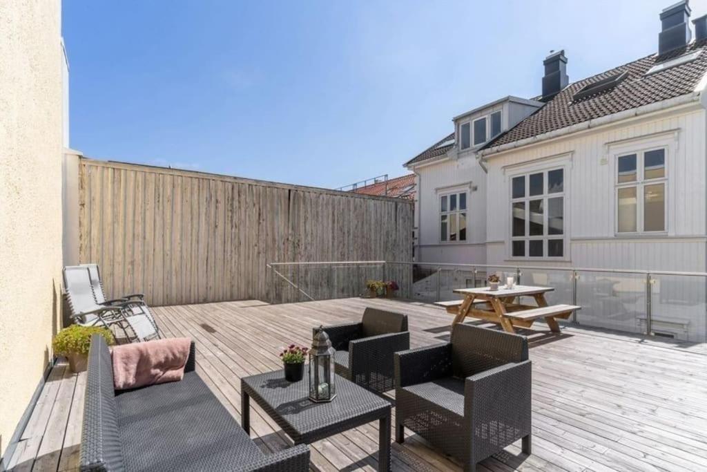 a patio with chairs and a table on a wooden deck at MyCondo no - Storgt 15b in Tønsberg