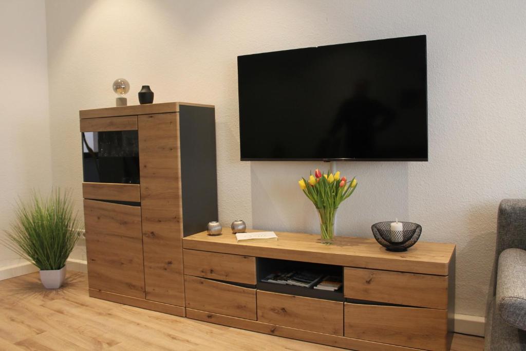 a wooden entertainment center with a flat screen tv on a wall at City-Appartement Pirna in Pirna