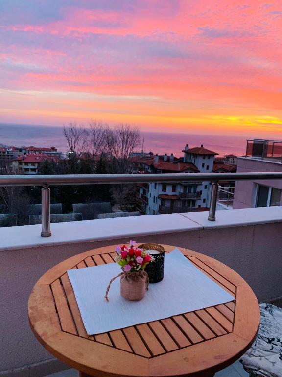 a table on a balcony with a pot of flowers at Kiwi Gardens in Byala