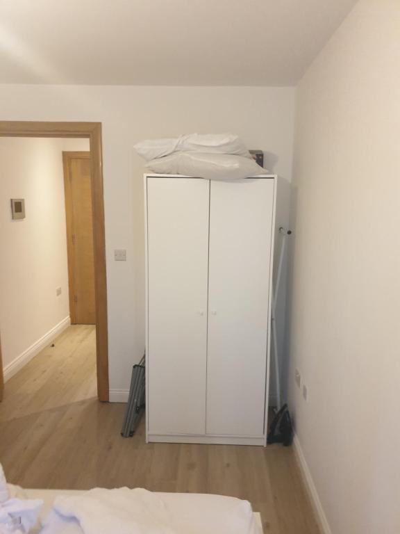 um armário branco no canto de um quarto em 133 Cornwall Road n15 5ax em Londres
