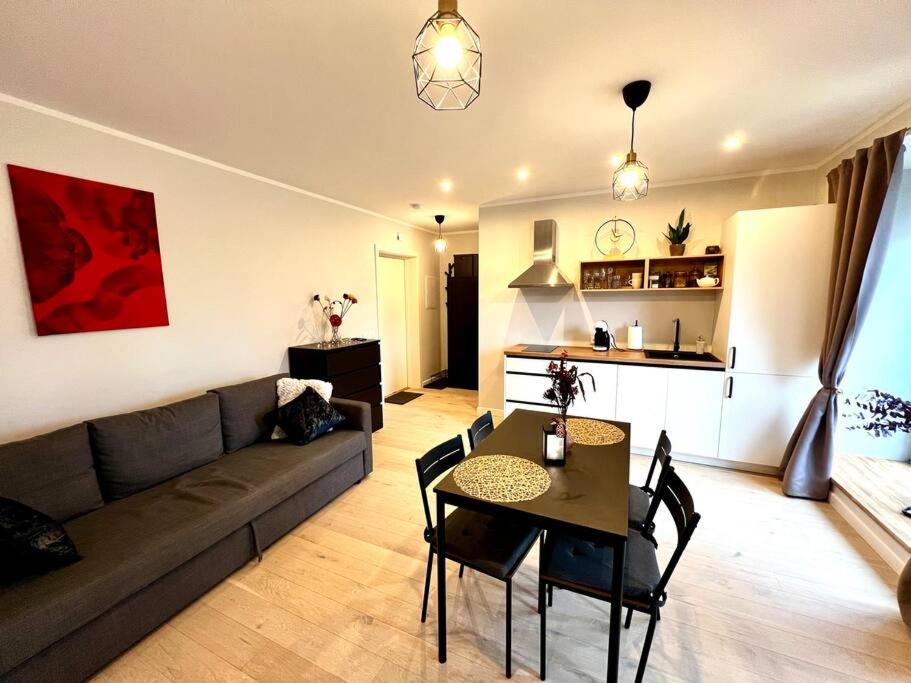 een woonkamer met een bank en een tafel bij Seashell Albatross Boutique Apartment in Ķesterciems