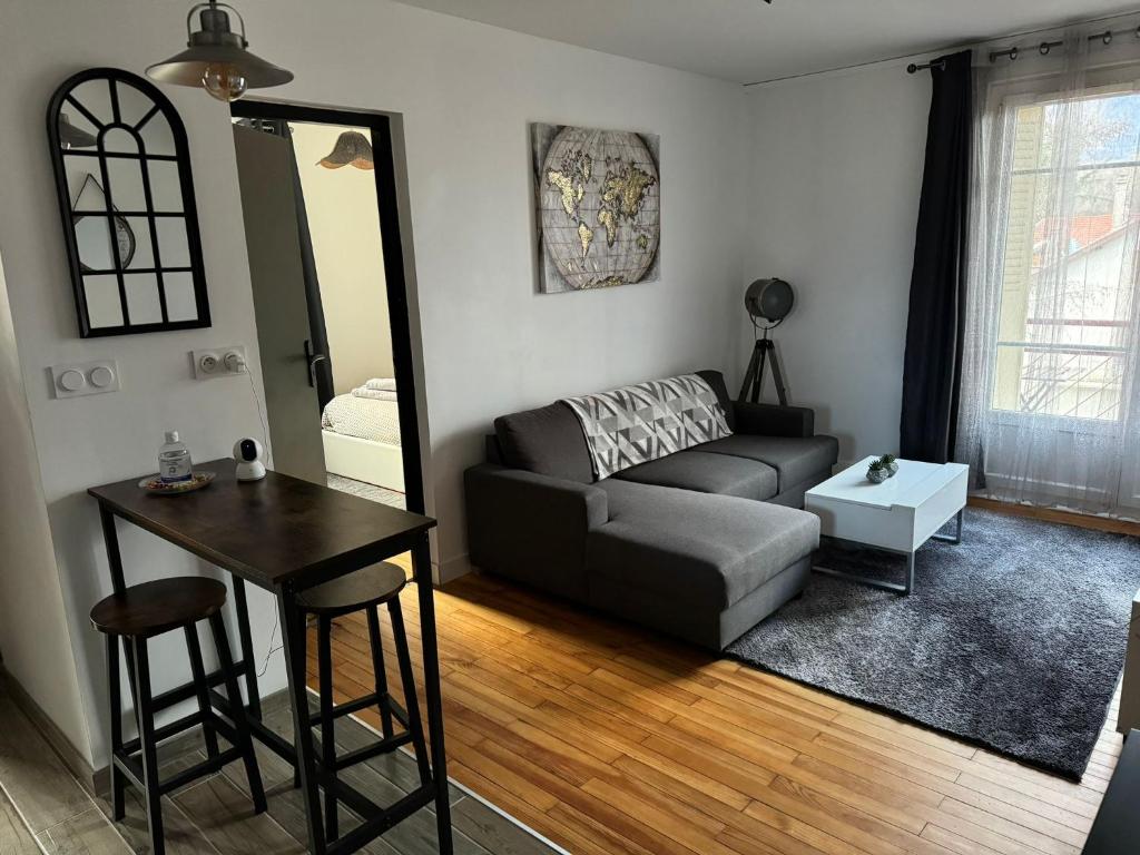 - un salon avec un canapé et une table dans l'établissement Appartement proche Grenoble centre et campus, à Saint-Martin-dʼHères