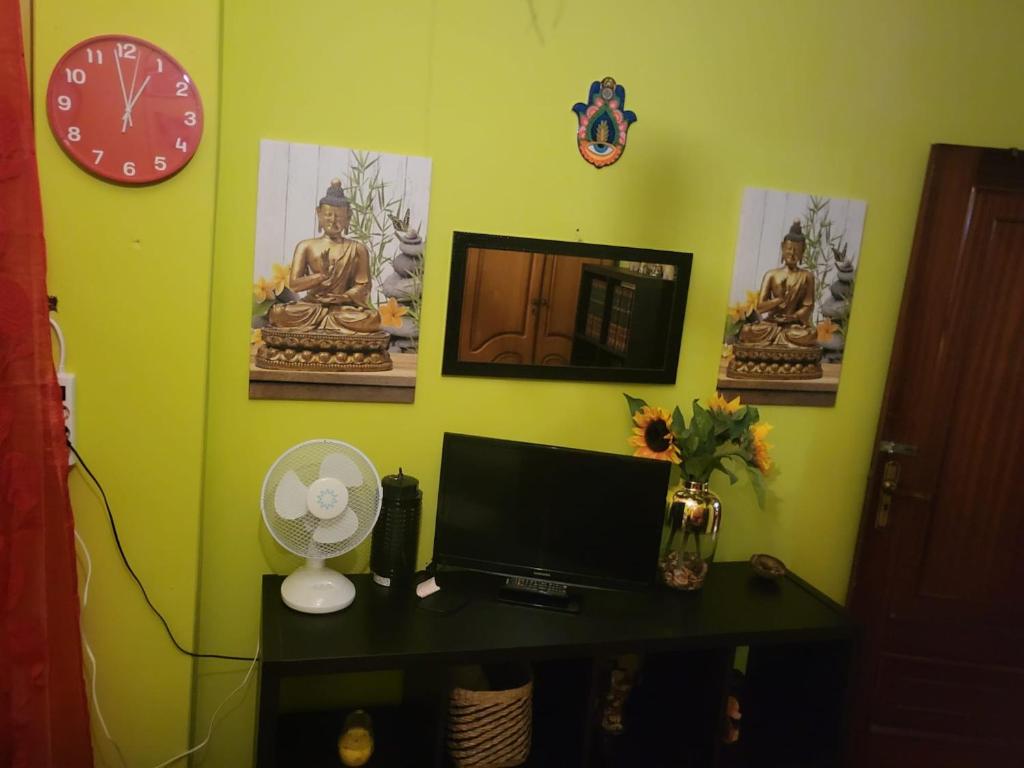 een kamer met een bureau met een monitor en een klok bij EL BUDHA in Pobra do Caramiñal