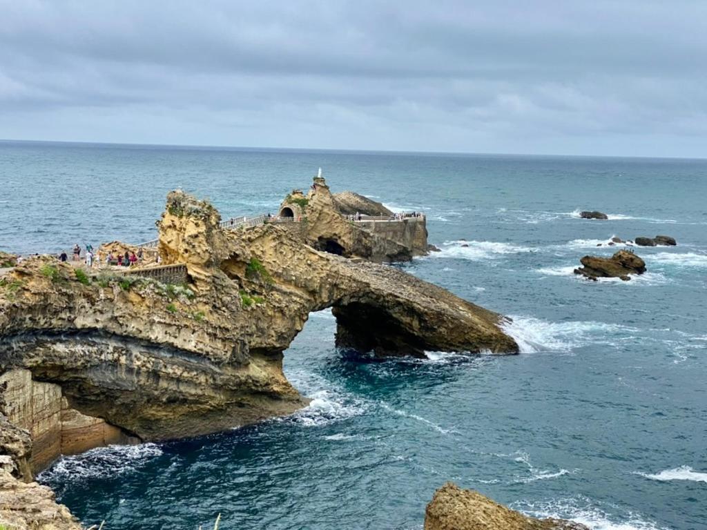 Un groupe de personnes debout sur une formation rocheuse dans l'océan dans l'établissement Superbe maisonnette au pied de la plage à Bidart 64, à Bidart