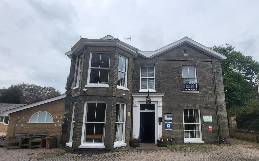 an old brick house with a black door at The Earlham Hotel in Norwich