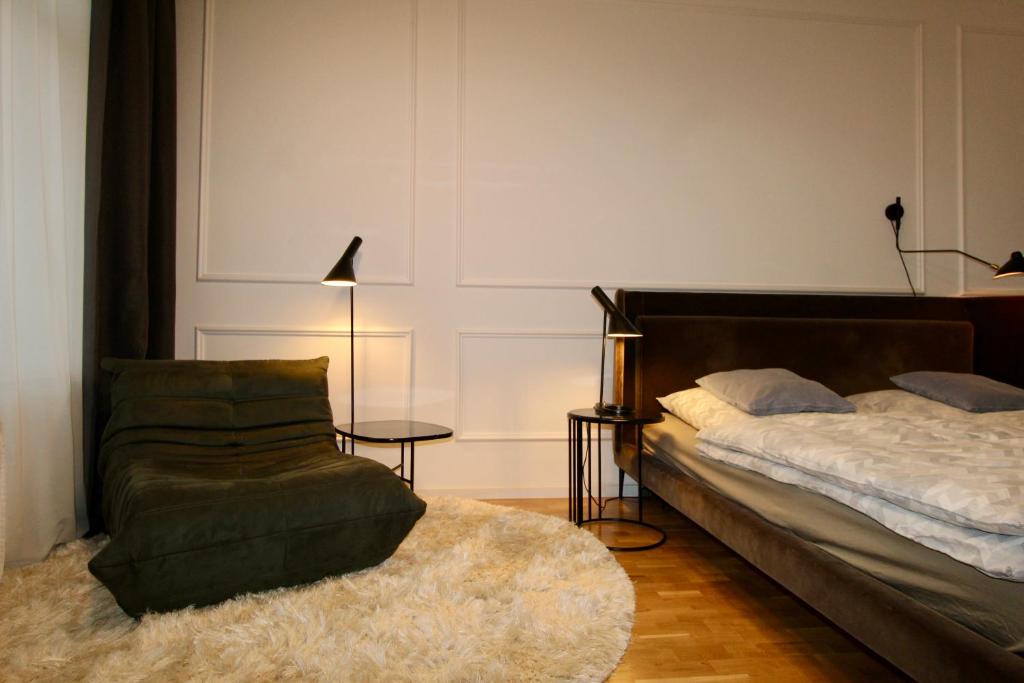 a bedroom with a bed and a chair and a table at Zentrales hochwertiges Gründerzeit-Apartment Thomasius in Leipzig