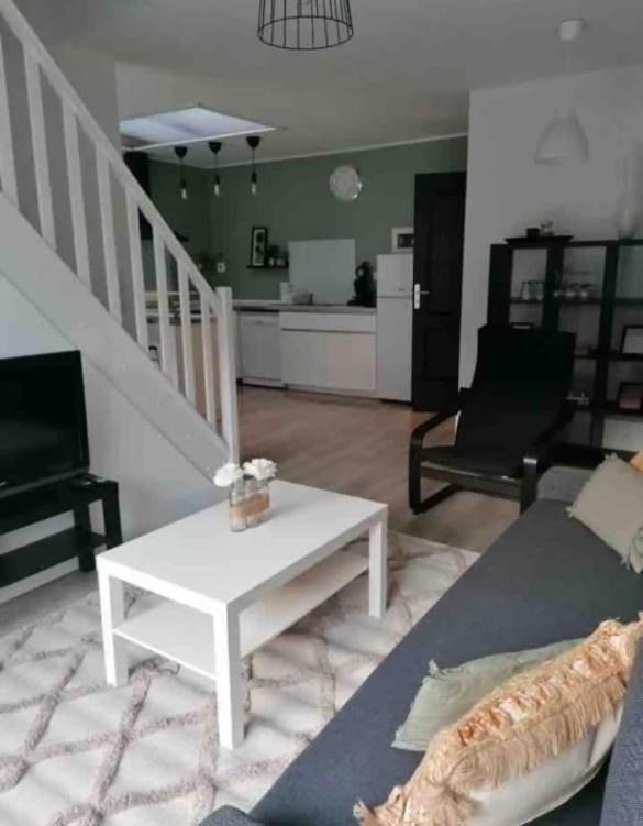 un salon avec un canapé et une table basse dans l'établissement Maison récente 2 chambres jardin et parking, à Wasquehal