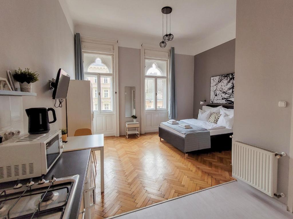 a kitchen and a living room with a couch at Mikszáth Apartments Budapest in Budapest