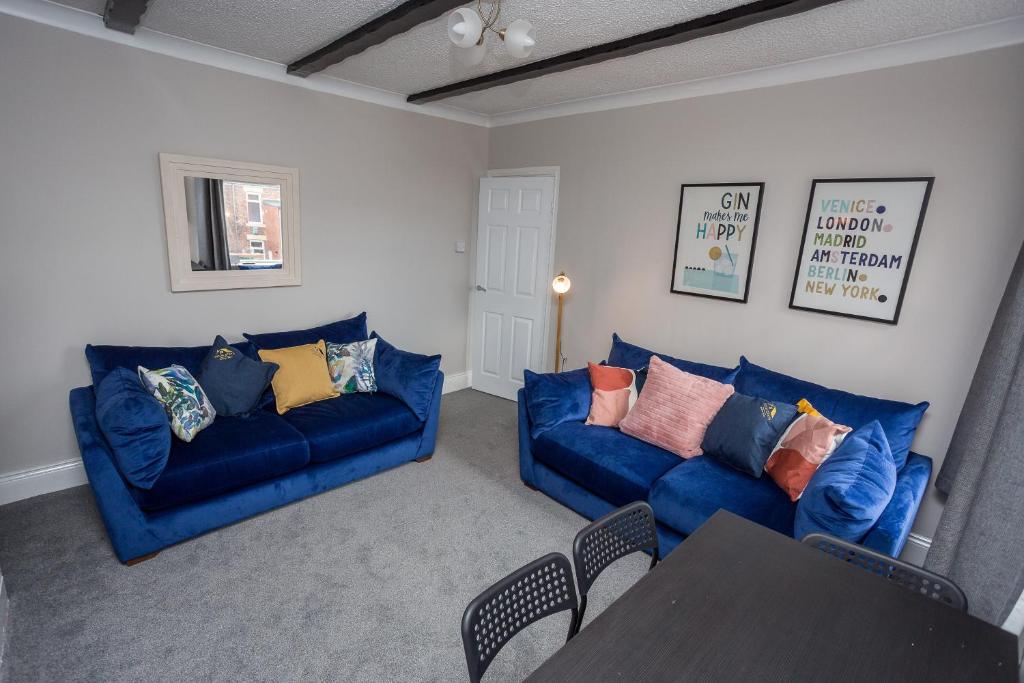 a living room with two blue couches and a table at The Avenue-3 bed sleeps 6 great for contractors in Gateshead